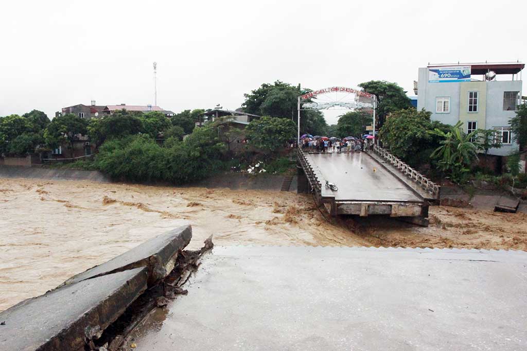 Warga melihat sebuah jembatan yang putus diterjang banjir di Provinsi Yen Bai, Vietnam, Rabu (11/10/2017). 