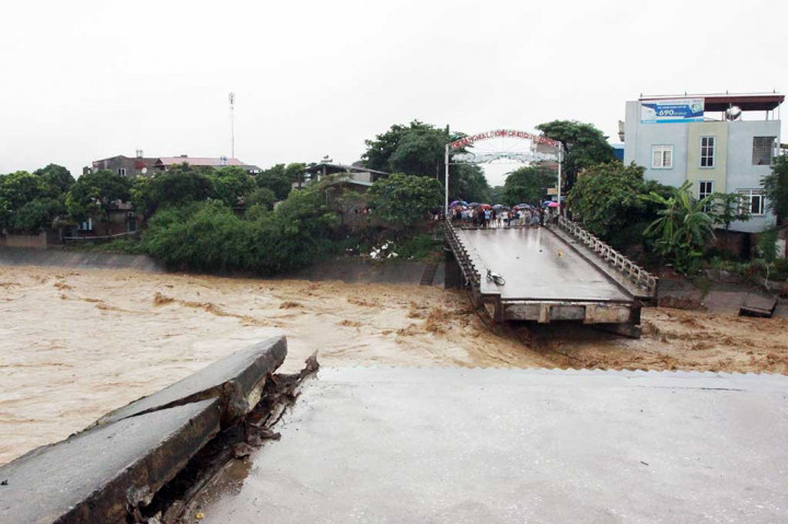 Warga melihat sebuah jembatan yang putus diterjang banjir di Provinsi Yen Bai, Vietnam, Rabu (11/10/2017). 