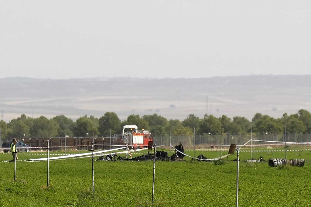 Seorang pria mendekati puing-puing pesawat Eurofighter yang jatuh di dekat sebuah pangkalan militer di Albacete, 300 km tenggara Madrid, Kamis (12/10/2017) waktu setempat. AFP/Luis Vizcaino