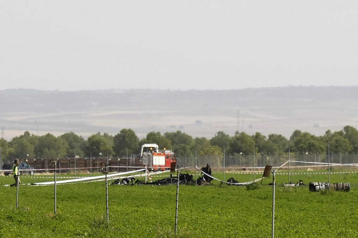 Seorang pria mendekati puing-puing pesawat Eurofighter yang jatuh di dekat sebuah pangkalan militer di Albacete, 300 km tenggara Madrid, Kamis (12/10/2017) waktu setempat. AFP/Luis Vizcaino