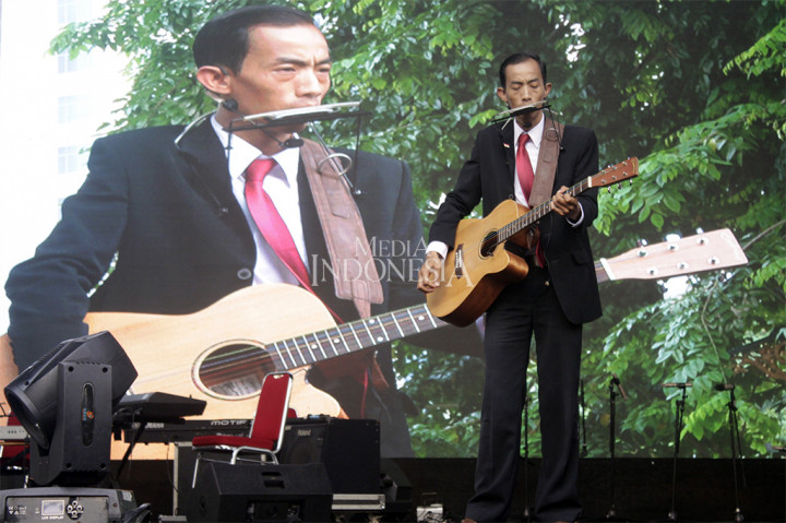 Aksi relawan Reza Srimulyadi yang mirip Presiden Joko Widodo saat bernyanyi pada acara Kaleidoskop dan Terimakasih Gubernur 2012-2017 di Lapangan Banteng, Jakarta.