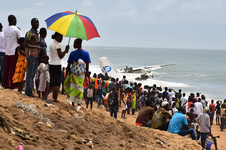 Orang berkumpul untuk melihat sisa-sisa kecelakaan pesawat kargo di dekat Abidjan.