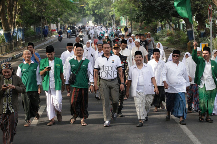 Kapolres Malang AKBP Yade Setiawan Ujung dan Ketua PCNU Kabupaten Malang Umar Usman bersama santri dan ulama jalan sehat sarungan memperingati Hari Santri Nasional di Stadion Kanjuruhan, Malang, Jawa Timur.
