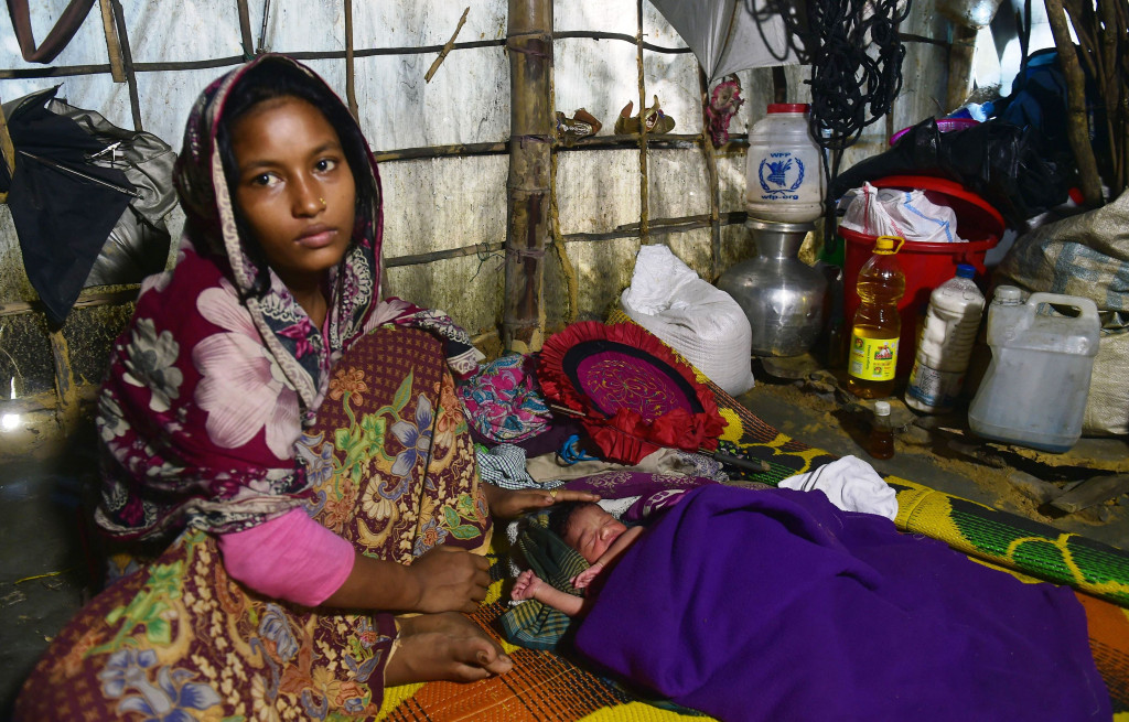 Hasina Aktar, seorang pengungsi Rohingya, bersama bayinya yang baru lahir di pengungsian. Mayoritas pengungsi adalah warga usia produktif.