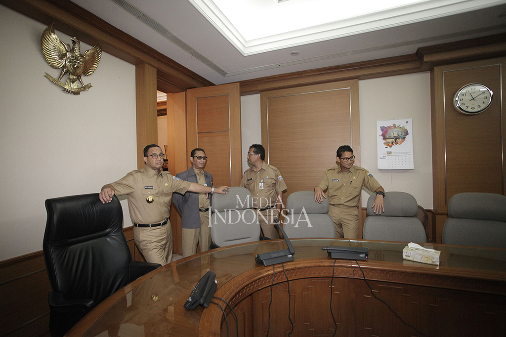 Gubernur DKI Jakarta Anies Baswedan bersama Wakil Gubernur Sandiaga Uno melihat ruangan rapat saat berkeliling di Kantor Balai Kota DKI Jakarta.