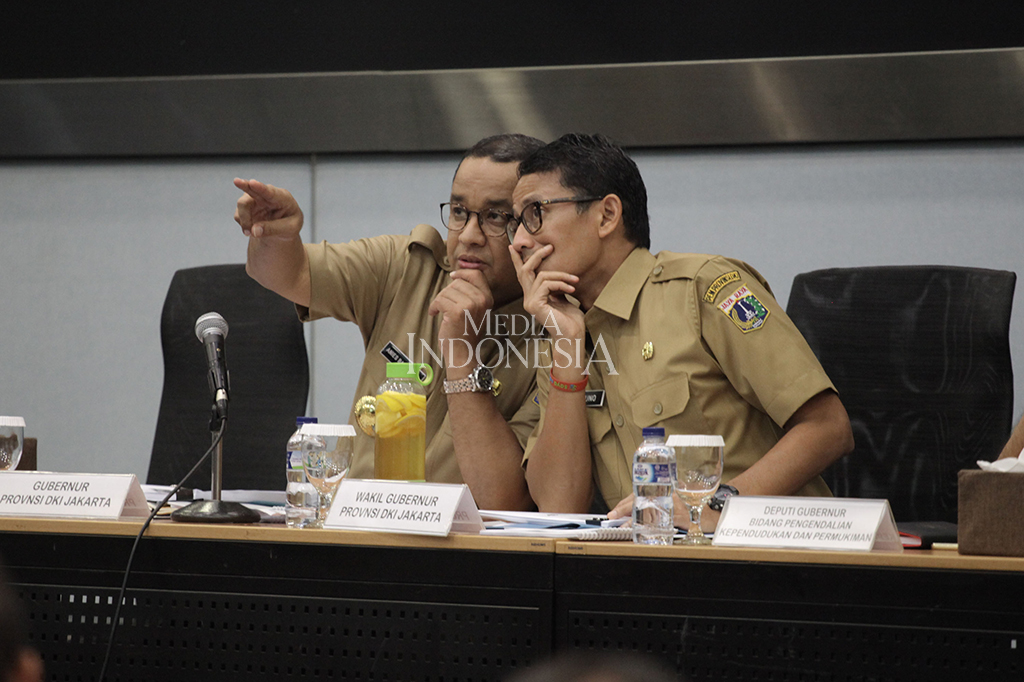 Gubernur DKI Jakarta Anies Baswedan berbincang bersama Wakil Gubernur Sandiaga Uno saat memimpin rapat bersama SKPD di Kantor Balai Kota DKI Jakarta.