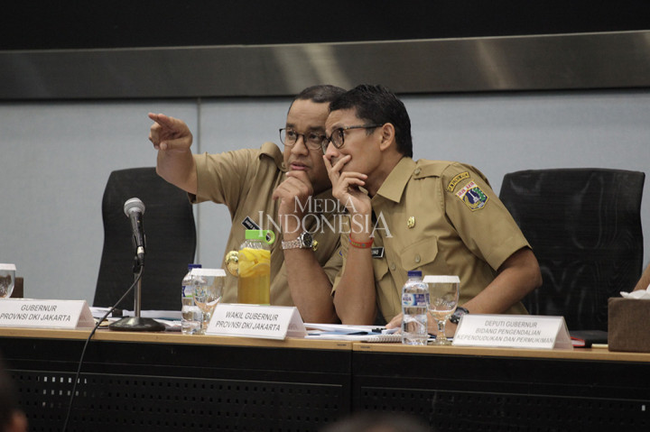 Gubernur DKI Jakarta Anies Baswedan berbincang bersama Wakil Gubernur Sandiaga Uno saat memimpin rapat bersama SKPD di Kantor Balai Kota DKI Jakarta.