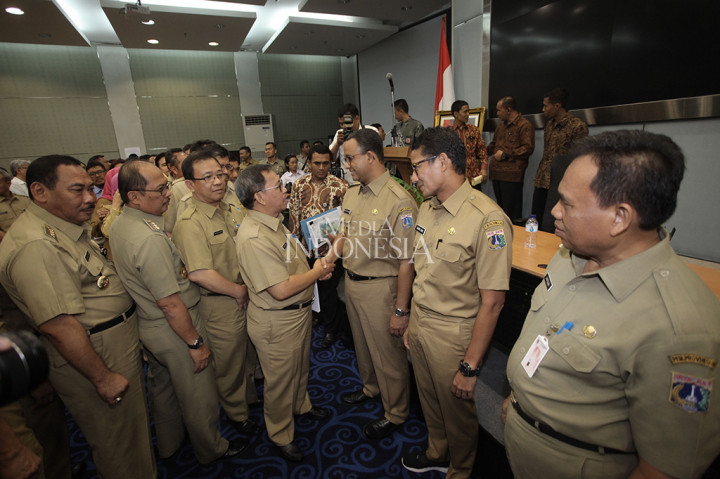 Gubernur DKI Jakarta Anies Baswedan bersama Wakil Gubernur Sandiaga Uno menerima ucapan selamat seusai rapat di Kantor Balai Kota DKI Jakarta.