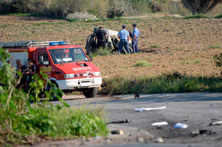 Polisi dan ahli forensik memeriksa reruntuhan mobil yang ditumpangi jurnalis dan blogger Daphne Caruana Galizia yang dibom di Bidnija, Malta, Senin (16/10/2017) waktu setempat.