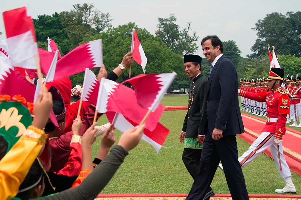 Anak-anak mengibarkan bendera Indonesia dan Qatar menyambut kedatangan Syekh Tamim di Istana Bogor.