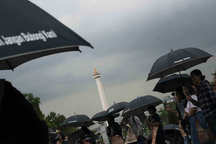 Para aktivis yang tergabung dalam Jaringan Solidaritas Korban untuk Keadilan (JSKK) melakukan aksi Kamisan di Silang Monas, Jakarta.
