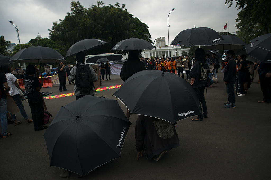 Para aktivis mengenakan payung hitam bertuliskan tuntutan-tuntutan kepada pemerintah seperti 'Tuntaskan Pelanggaran HAM', 'Lindungi Buruh Migran', 'Tuntaskan Tragedi Wasior Wamena' dan lain-lain.