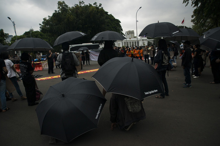 Para aktivis mengenakan payung hitam bertuliskan tuntutan-tuntutan kepada pemerintah seperti 'Tuntaskan Pelanggaran HAM', 'Lindungi Buruh Migran', 'Tuntaskan Tragedi Wasior Wamena' dan lain-lain.