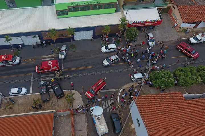 Warga berkumpul di luar sekolah swasta Goyases di Goiania, negara bagian Goias, Brasil, pascapenembakan, Jumat (20/10/2017) waktu setempat.