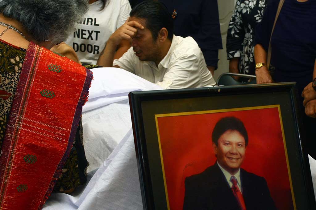 Dino Panjaitan menangis disamping jenazah ayahnya Benny Panjaitan yang disemayamkan di Rumah Duka RS Darmais, Jakarta, Selasa (24/10/2017).