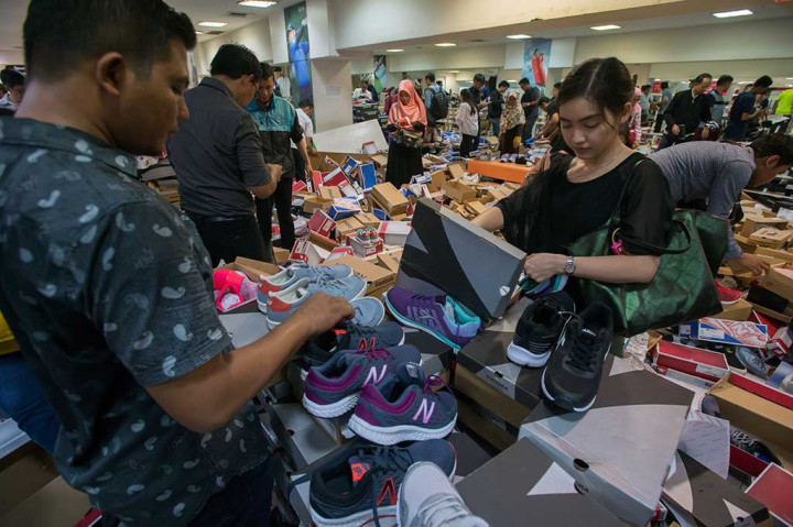Pembeli memilih berbagai merk sepatu yang dijual dengan potongan harga di gerai sepatu dan alat olahraga yang ada di pusat perbelanjaan Lotus.