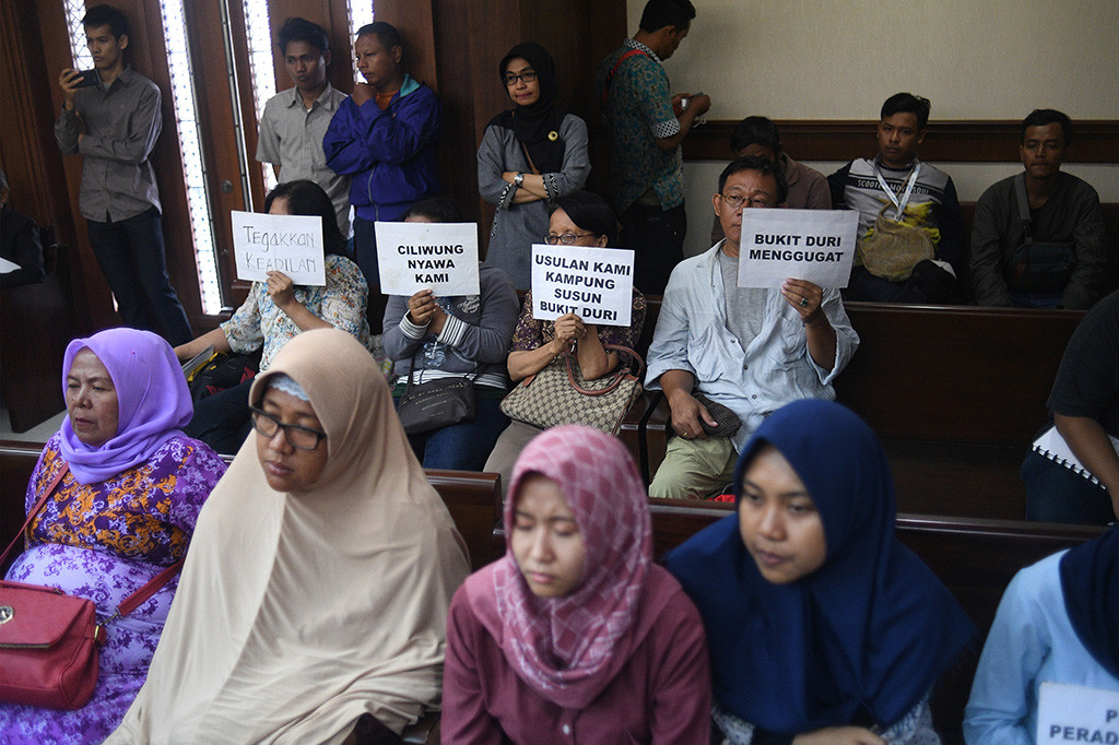 Warga mengikuti sidang putusan gugatan perwakilan kelompok (class action) warga Bukit Duri terhadap Pemprov DKI Jakarta dan sejumlah pihak tergugat di Pengadilan Negeri Jakarta Pusat, Jakarta, Rabu (25/10/2017). 
