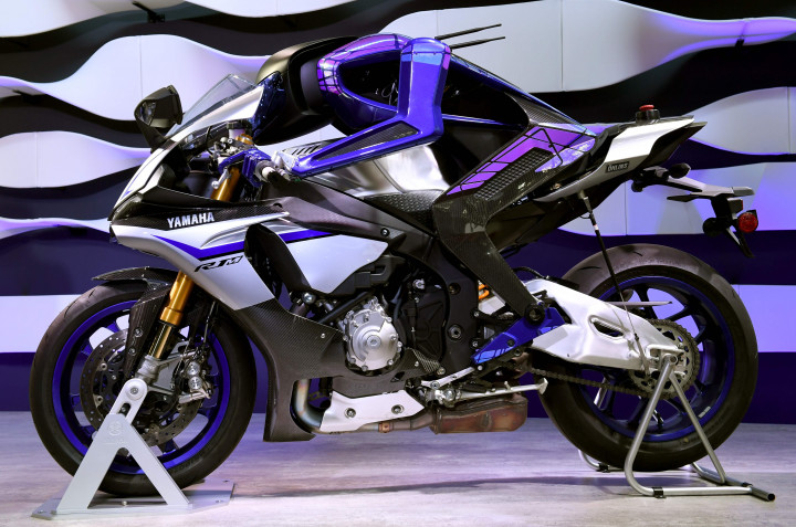 Bukan superbike Yamaha RI yang menarik di sini, melainkan sosok biru yang duduk di sadelnya. Dia adalah Motobot, sebuah robot yang Yamaha bekali teknologi autonomous. AFP Photo/Toshifumi Kitamura