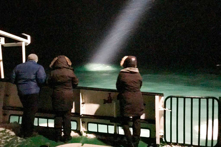 Wisatawan melihat ke laut di atas kapal wisata Langoysund, yang turut dikerahkan untuk mencari keberadaan helikopter Rusia yang jatuh di perairan Svalbard, Kepulauan Arktik, Kamis (26/10/2017) waktu setempat. AFP/NTB scanpix/Jostein Forsberg