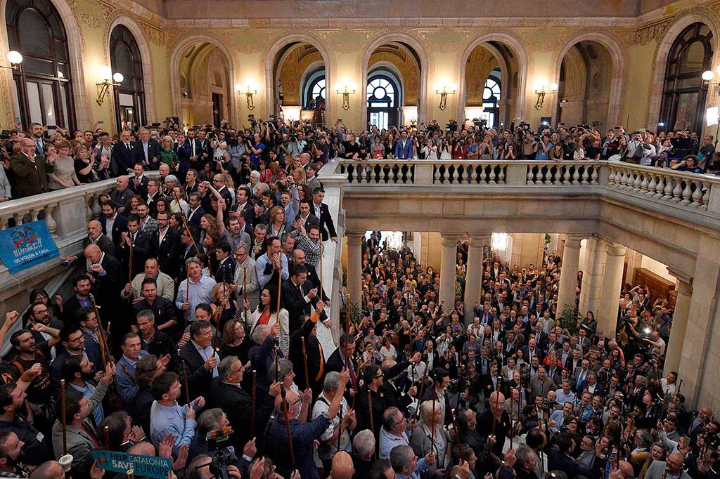 Wali kota yang datang dari daerah terpencil mengacungkan tongkat seremonial mereka dan menyanyikan lagu kebangsaan Catalan 'Els Segadors' (Para Penuai). AFP/Lluis Gene