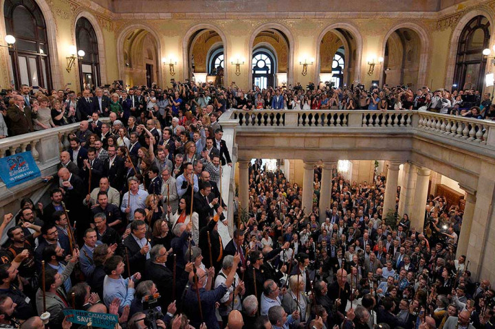 Wali kota yang datang dari daerah terpencil mengacungkan tongkat seremonial mereka dan menyanyikan lagu kebangsaan Catalan 'Els Segadors' (Para Penuai). AFP/Lluis Gene