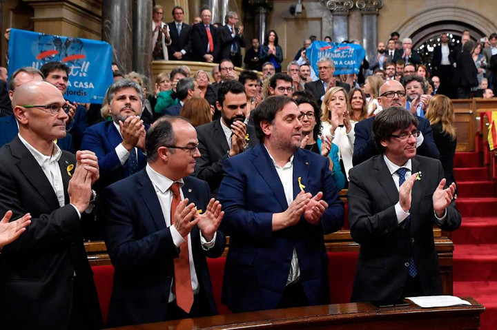 Presiden Catalan Carles Puigdemont (kanan) bertepuk tangan bersama anggota kabinetnya Oriol Junqueras (kedua kanan), Jordi Turull (ketiga kanan) dan Raul Romeva (kiri) setelah parlemen Catalonia memilih untuk menyatakan kemerdekaan dari Spanyol.  AFP/Lluis Gene