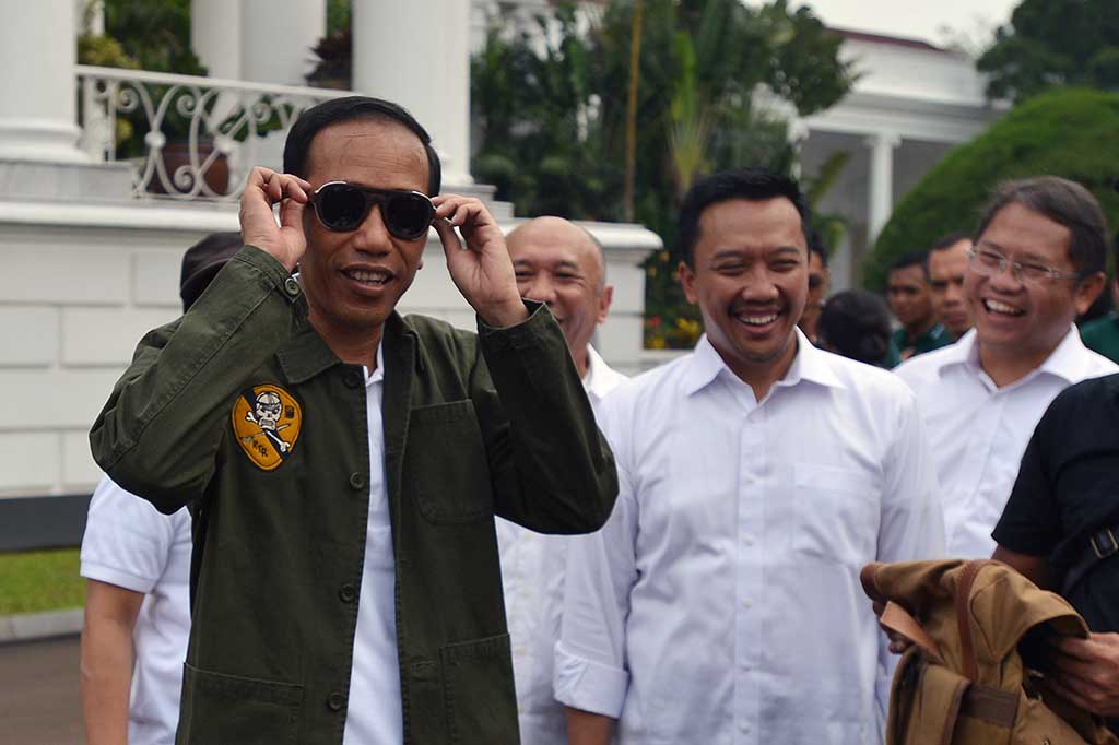 Presiden Joko Widodo disaksikan Kepala Staf Kepresidenan Teten Masduki (kedua kiri), Menpora Imam Nahrawi (kedua kanan) dan Menkominfo Rudiantara mencoba kacamata produk lokal di salah satu stan saat peringatan Hari Sumpah Pemuda ke-89 di halaman Istana Bogor, Jawa Barat, Sabtu (28/10/2017).