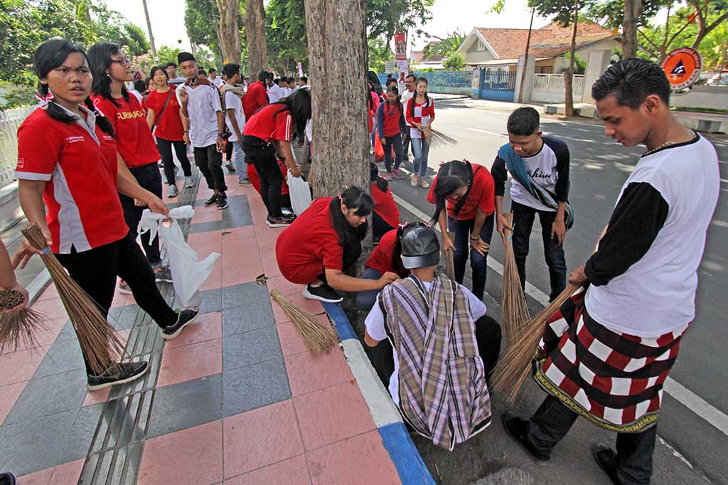 Pelajar melakukan aksi bersih-bersih di pinggir jalan di Banyuwangi, Jawa Timur. Aksi dalam rangka memperingati Hari Sumpah Pemuda itu dilakukan untuk memberikan edukasi dalam merawat lingkungan dan kebersihan kota. ANTARA/Budi Candra Setya