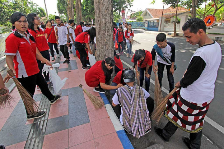 Pelajar melakukan aksi bersih-bersih di pinggir jalan di Banyuwangi, Jawa Timur. Aksi dalam rangka memperingati Hari Sumpah Pemuda itu dilakukan untuk memberikan edukasi dalam merawat lingkungan dan kebersihan kota. ANTARA/Budi Candra Setya