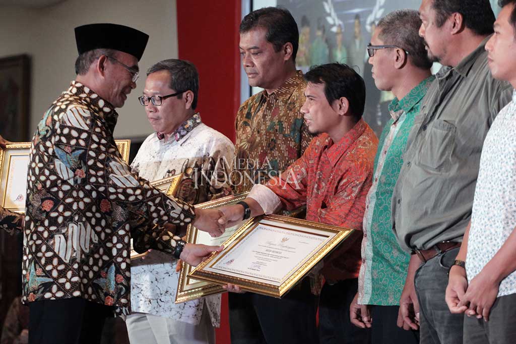 Menteri Pendidikan dan Kebudayaan Muhajir Effendi (kiri) menyerahkan penghargaan Media Massa Cetak Berbahasa Indonesia Terbaik kepada Media Indonesia yang diterima oleh Redaktur Bahasa Dony Tjiptonugroho dalam puncak Hari Bahasa dan Sasta-Gerakan Literasi Nasional di Kantor Kemendikbud, Jakarta, Sabtu (28/10/2017).