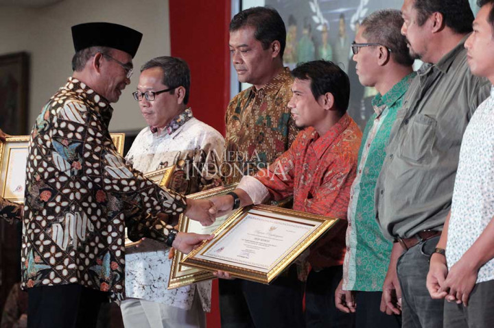 Menteri Pendidikan dan Kebudayaan Muhajir Effendi (kiri) menyerahkan penghargaan Media Massa Cetak Berbahasa Indonesia Terbaik kepada Media Indonesia yang diterima oleh Redaktur Bahasa Dony Tjiptonugroho dalam puncak Hari Bahasa dan Sasta-Gerakan Literasi Nasional di Kantor Kemendikbud, Jakarta, Sabtu (28/10/2017).