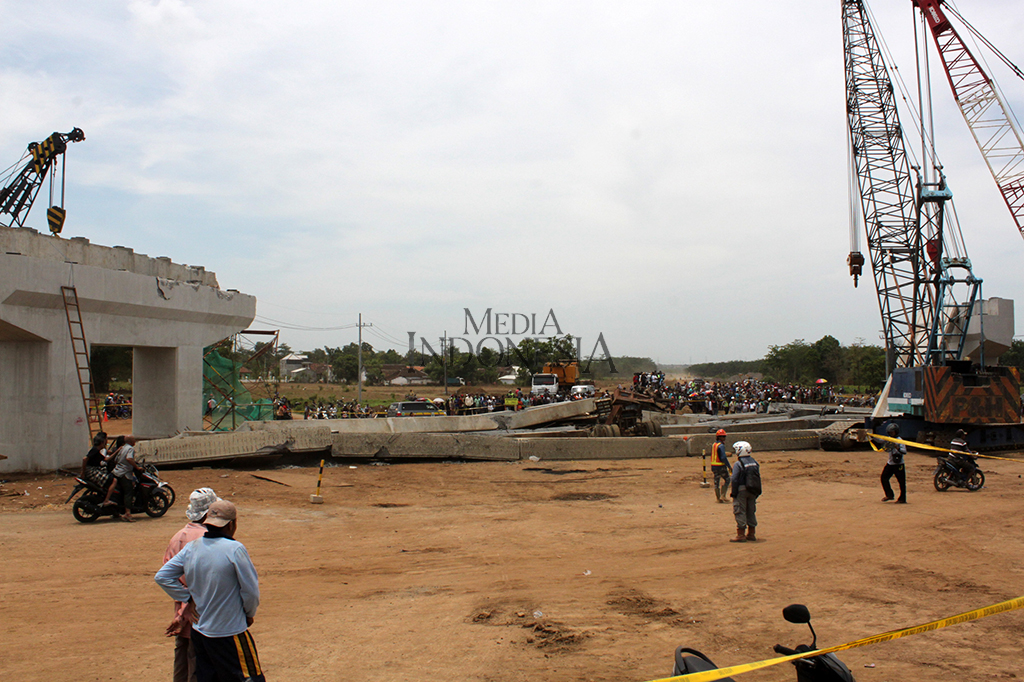 Tempat kejadian perkara sudah dipasang garis polisi. Ratusan warga berkerumun melihat TKP dari luar garis. 