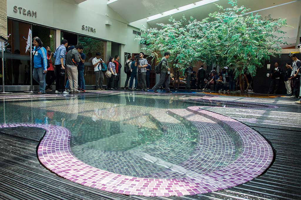 Terdapat kolam cetek dengan lantai keramik warna-warni tempat pengunjung bersantai.