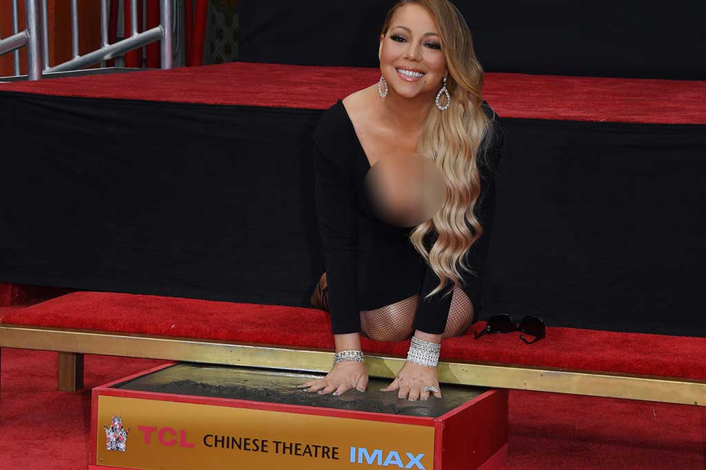 Mariah Carey tanpa canggung mencetak tangannya di semen di TCL Chinese Theatre, Los Angeles. 