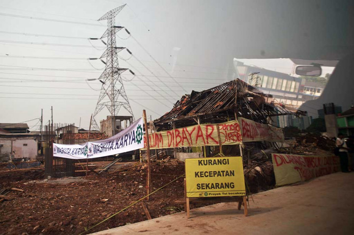 Meski sudah diresmikan Presiden, Tol Becakau masih menyisakan masalah pembebasan lahan. Sejumlah warga memasang spanduk sebagai protes lahan mereka yang belum dibayar.