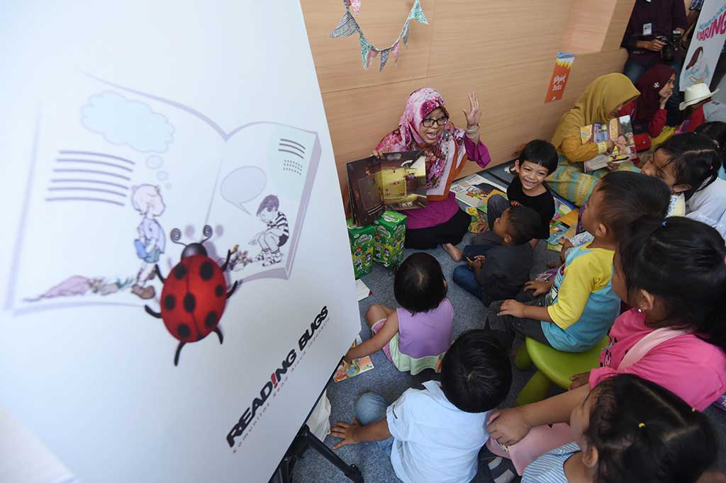 Seorang pegiat membacakan buku cerita kepada anak-anak pada Festival Dongeng Internasional Indonesia (FDII) 2017 di Perpustakaan Nasional, Jakarta, Sabtu (4/11). FDII 2017 merupakan kegiatan yang digelar Komunitas Ayo Dongeng Indonesia (AyoDI) pada 4-5 November 2017. Tahun ini untuk ketiga kalinya festival tersebut dilaksanakan pada taraf internasional.