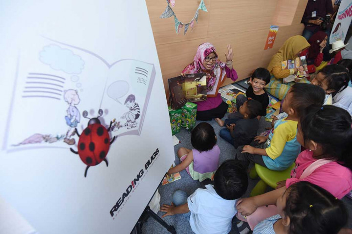 Seorang pegiat membacakan buku cerita kepada anak-anak pada Festival Dongeng Internasional Indonesia (FDII) 2017 di Perpustakaan Nasional, Jakarta, Sabtu (4/11). FDII 2017 merupakan kegiatan yang digelar Komunitas Ayo Dongeng Indonesia (AyoDI) pada 4-5 November 2017. Tahun ini untuk ketiga kalinya festival tersebut dilaksanakan pada taraf internasional.