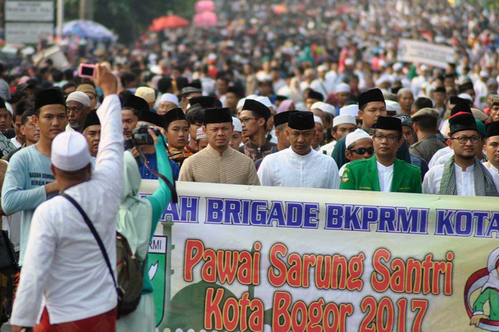 Wali Kota Bogor Bima Arya (tengah) bersama pimpinan ormas Islam dan pondok pesantren dan ribuan santri berjalan kaki menggunakan sarung saat Jalan Sehat Sarungan di jalan RE.Martadinata, Kota Bogor, Jawa Barat, Minggu (5/11/2017). ANTARA/Arif Firmansyah