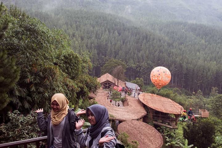 Wisatawan berfoto dengan latar belakang hutan pinus di kawasan wisata Lodge Maribaya, Kabupaten Bandung Barat.