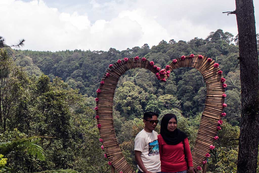 Wisatawan berfoto dengan latar belakang hutan pinus di kawasan wisata Lodge Maribaya, Kabupaten Bandung Barat.