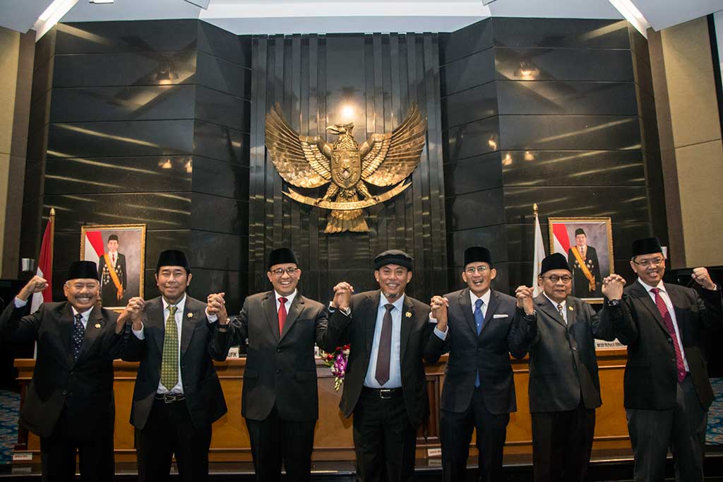 Gubernur DKI Jakarta Anies Baswedan (ketiga kiri), Wagub Sandiaga Uno (ketiga kanan), Ketua DPRD DKI Jakarta Prasetio Edi Marsudi (tengah) dan keempat Wakil Ketua DPRD DKI Jakarta Abraham Lunggana (kedua kiri), Mayjend TNI (Purn) Ferrial Sofyan (kiri), Mohamad Taufik (kedua kanan), Triwisaksana bergandeng tangan bersama seusai mengikuti rapat paripurna di DPRD DKI Jakarta.