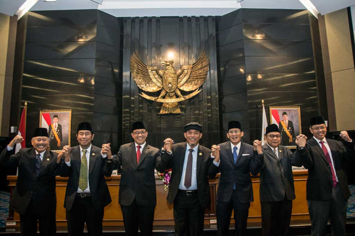 Gubernur DKI Jakarta Anies Baswedan (ketiga kiri), Wagub Sandiaga Uno (ketiga kanan), Ketua DPRD DKI Jakarta Prasetio Edi Marsudi (tengah) dan keempat Wakil Ketua DPRD DKI Jakarta Abraham Lunggana (kedua kiri), Mayjend TNI (Purn) Ferrial Sofyan (kiri), Mohamad Taufik (kedua kanan), Triwisaksana bergandeng tangan bersama seusai mengikuti rapat paripurna di DPRD DKI Jakarta.