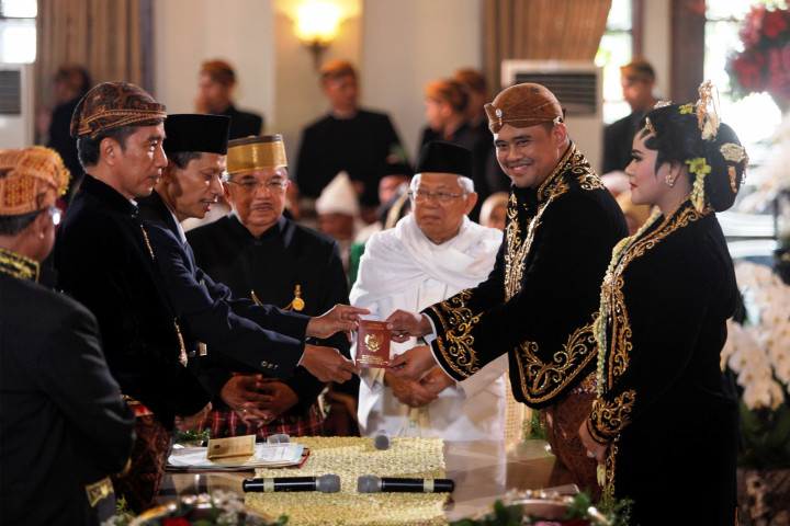 Bobby Nasution menerima buku nikah dari Kepala KUA Banjarsari, Surakarta, Bashir, yang bertindak sebagai penghulu. 