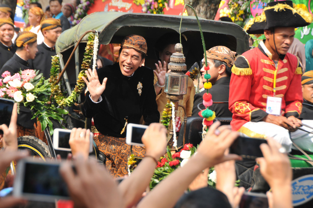 Presiden Jokowi dan Ny. Iriana membalas sambutan hangat dari warga di sepanjang perjalanan menuju Grha Saba. 