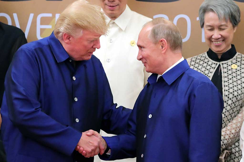 Donald Trup dan Vladimir Putih telah bertemu di Da Nang tiga kali sejak Jumat (10/11/2017) malam. Pertama saat mereka berpose untuk berfoto bersama dengan baju tradisional. AFP/Sputnik/Mikhail Klimentyev