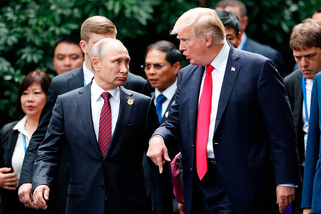 Dan kemudian berbincang sebentar, saat mereka berjalan bersama ke sebuah podium untuk foto bersama para peserta KTT APEC. AFP/Jorge Silva