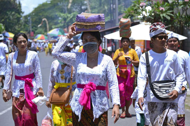 Umat Hindu mulai dari dewasa hingga anak-anak berbondong-bondong melaksanakan persembahyangan bersama di Denpasar, Bali, Sabtu (11/11/2017). AFP/Sony Tumbelaka