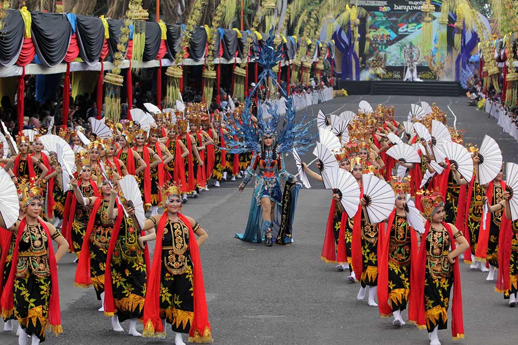 Model diiringi penari gandrung memperagakan kostum hasil rancangan desainer lokal pada ajang Banyuwangi Ethno Carnival 2017, di Taman Blambangan, Banyuwangi, Jawa Timur, Sabtu (11/11/2017).