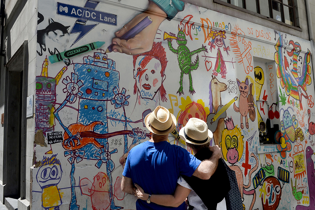 Orang-orang melihat karya seni di AC/DC Lane di Melbourne.