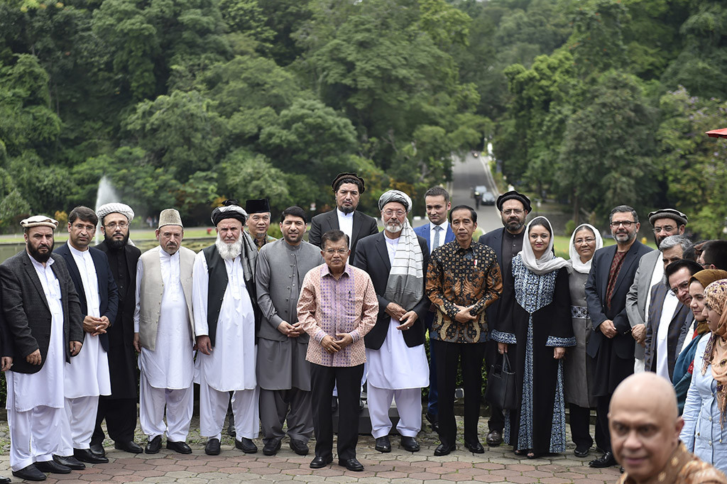 Presiden Joko Widodo bersama Wakil Presiden Jusuf Kalla, Duta Besar Indonesia untuk Afghanistan Arief Rachman, Ketua Mejelis Tinggi Perdamaian Afghanistan Mohammad Karim Khalili bersama delegasi berfoto bersama usai pertemuan di Resto Cafe Grand Garden, Kebun Raya Bogor, Jawa Barat.